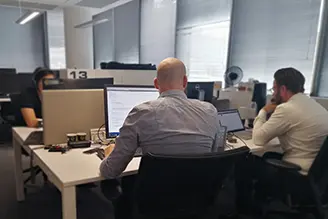Utviklere som jobber ved skjermer i et kontorlandskap